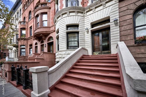 a row of brownstone buildings and stoops in an iconic neighborhood of Manhattan, New York City