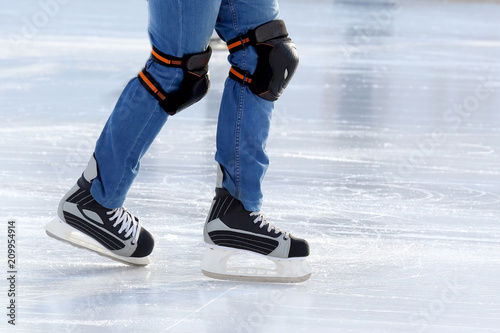 feet on the skates of a person rolling on the ice rink