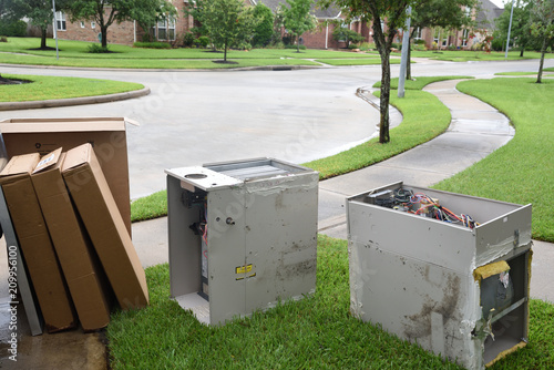 Old gas furnace units sitting at curb after technician has replaced units with new heaters