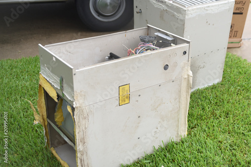 Old gas furnace units sitting at curb after technician has replaced units with new heaters