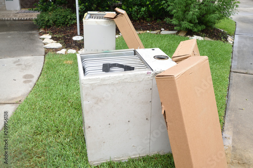 Old gas furnace units sitting at curb after technician has replaced units with new heaters