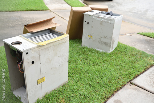 Broken and rusted gas furnace sitting on curb for trash pick up