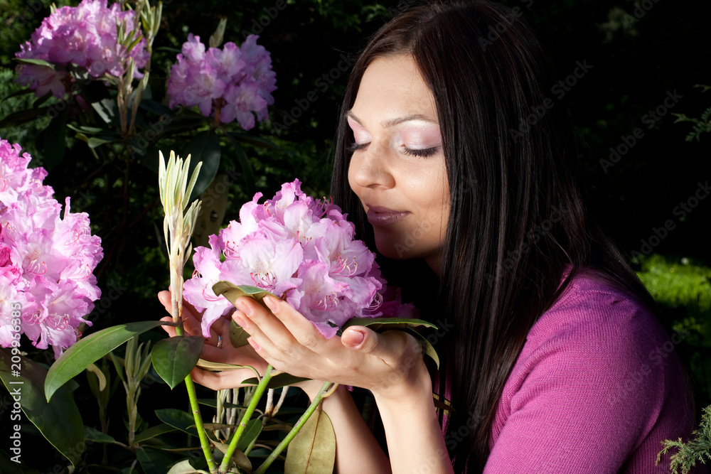 Naklejka premium woman smiling outdoors with some flowers