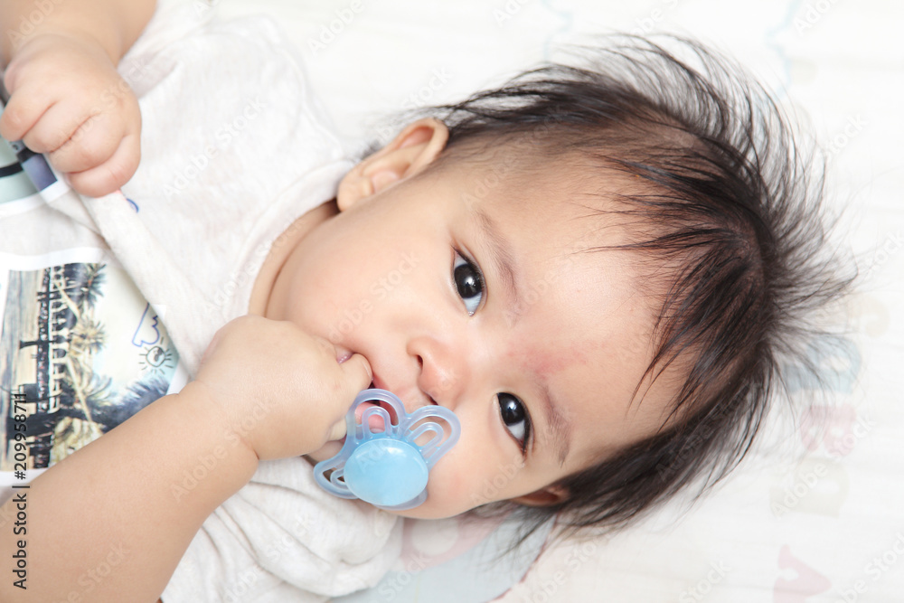 Bright eyes and innocent of asian baby on the bed in bedroom at home Bright eyes and innocent of asian baby on the bed in bedroom at home