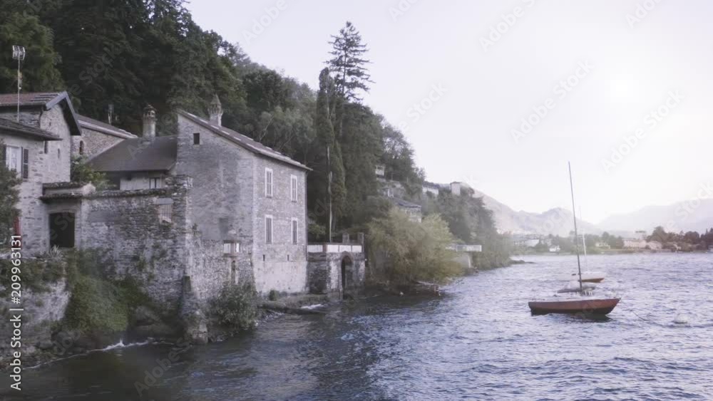 House on the shore of the Como Lake, Italy. Sailboat in front of an Old house. House on the shore of the Como Lake, Italy. Sailboat in front of an Old house.
