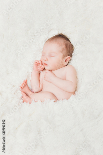 newborn baby lying on a white background. Imitation of a baby in the womb. beautiful little girl sleeping lying on her back.