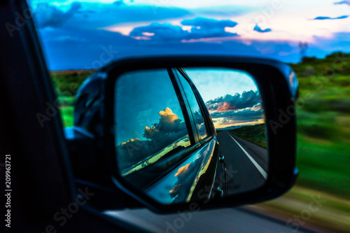 Storm clouds reflection in mirror of moving automobile