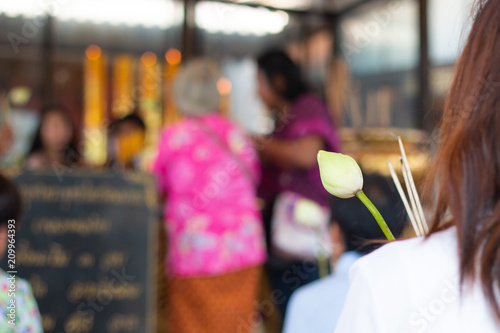 buddhist pray and worship with lotus flower and incense and blurred temple background