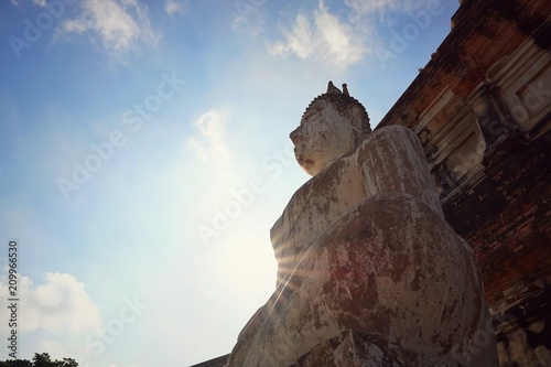 Travel Thailand - Buddha statue in Wat Yai Chaimongkol on blue sky and cloud background, Ayutthaya Historical Park. The brick pagoda at old ayutthaya temple ruins. Space for text in template.