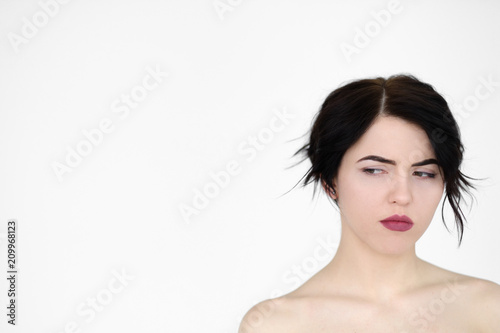 emotion face. suspicious thoughtful dubious distrustful woman looking sideways. young beautiful brunette girl portrait on white background.