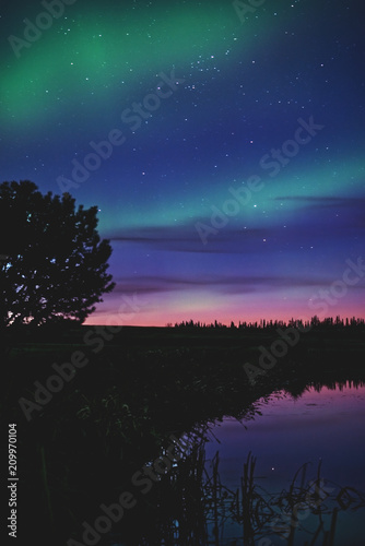 northern lights with stars and water reflection