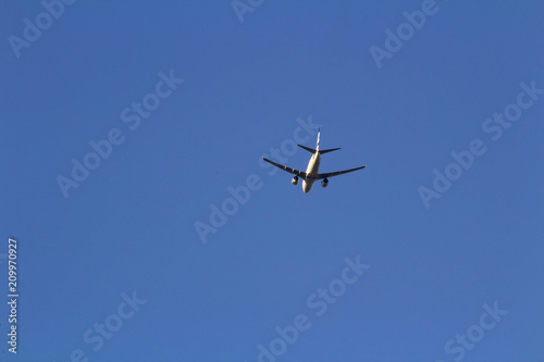 Passenger plane from below on blue sky, copy space