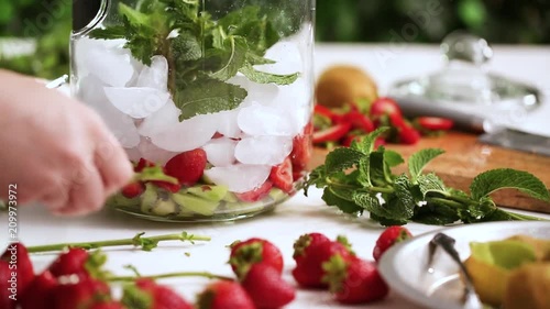 Time lapse. Step by step. Preparing organic infused water in glass beverage drink dispenser