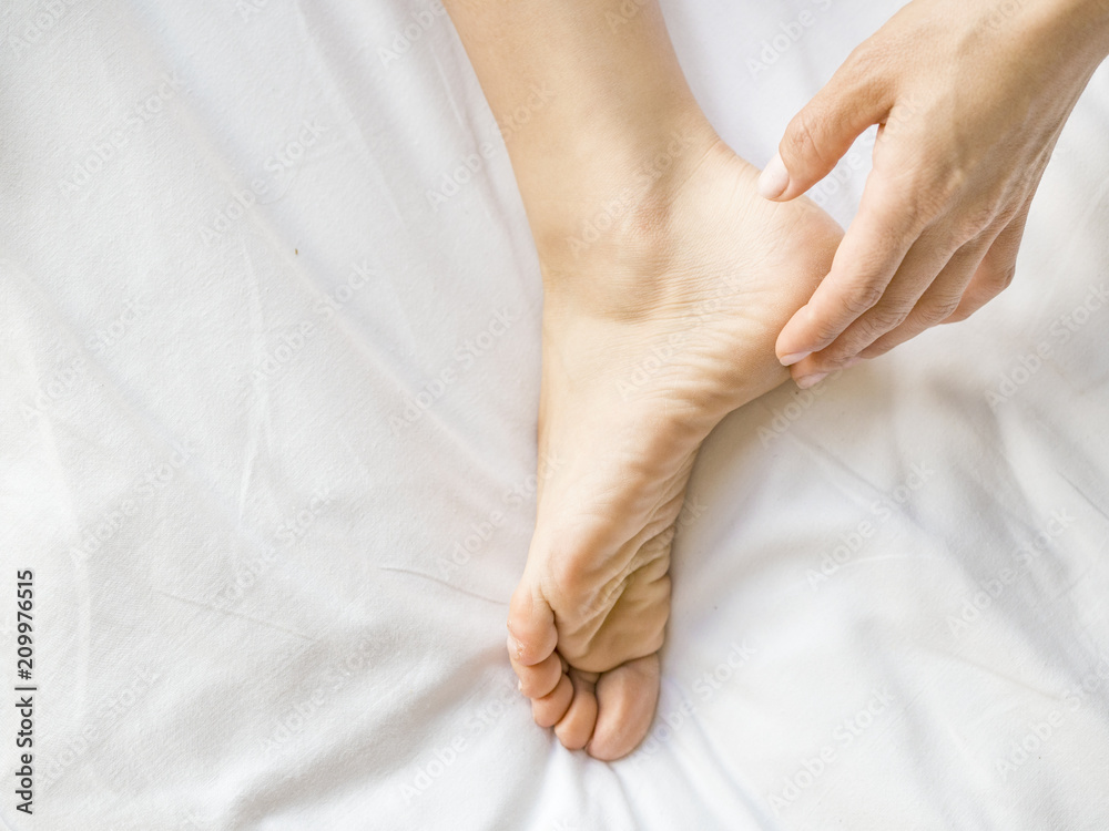 Woman applying cream onto her feet, closeup. Woman applying cream onto her feet, closeup.