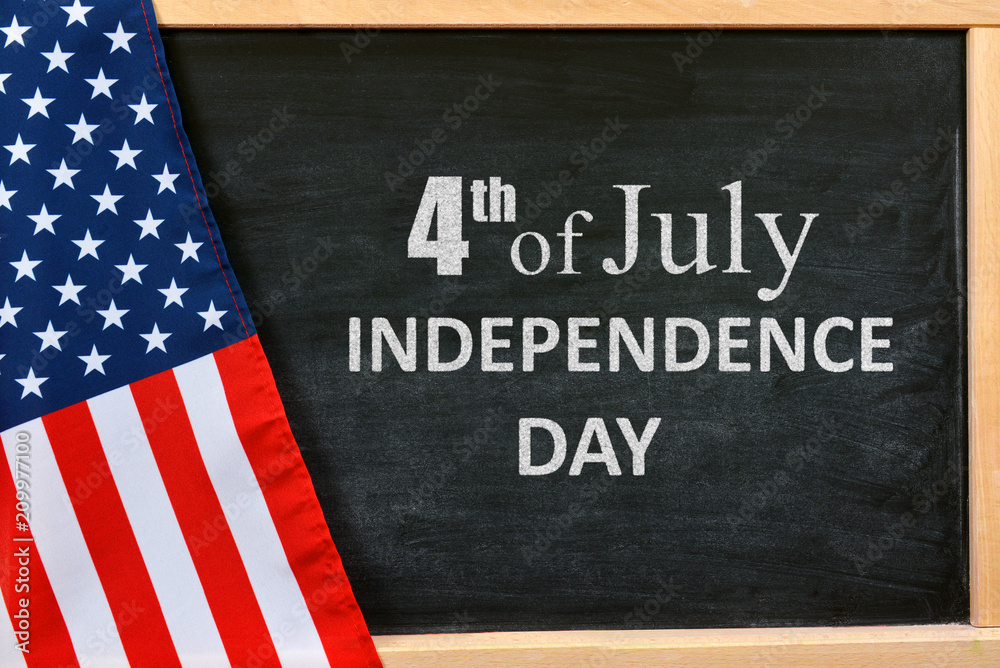4th of July Independence Day written on table with American flag. 4th of July Independence Day written on table with American flag.