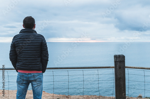 Man watching the sunset over the ocean at Port Noarlunga © Wade