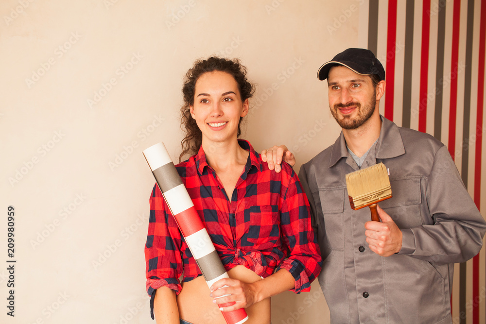 Couple doing repair at home. Woman with red wallpaper. Repair concept with copy space.