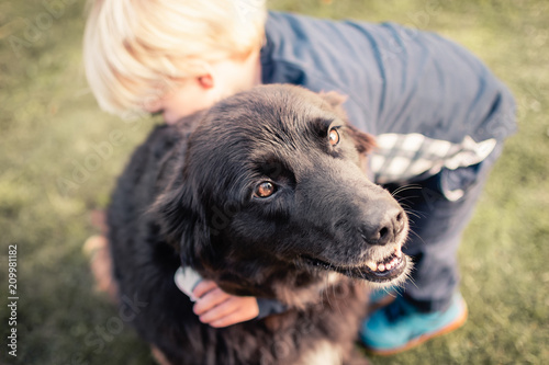 Toddler boy giving a dog a hug