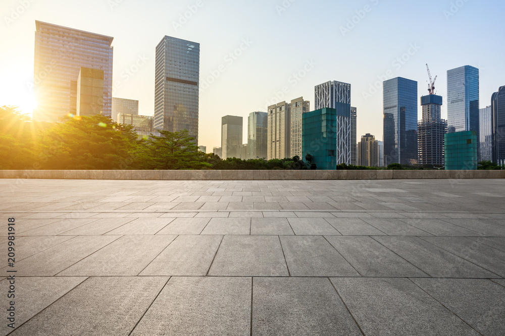 Empty square floor and modern commercial building at sunrise in Shenzhen