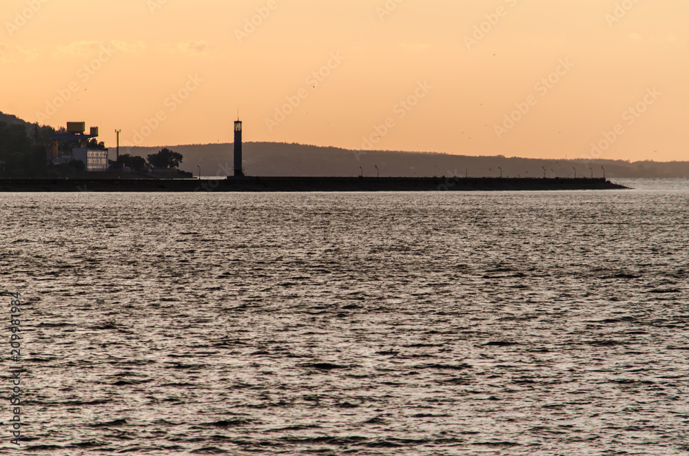 Landscape with silhouette of lighthouse in sunrice light Landscape with silhouette of lighthouse in sunrice light