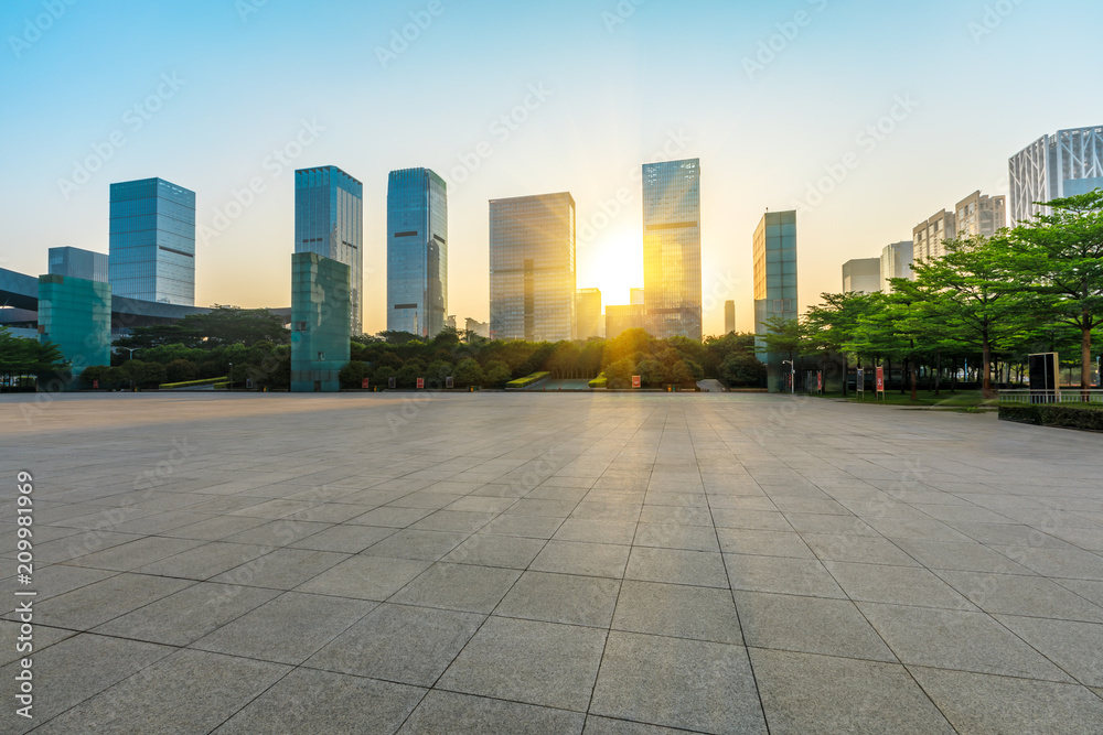 Empty square floor and modern commercial building at sunrise in Shenzhen