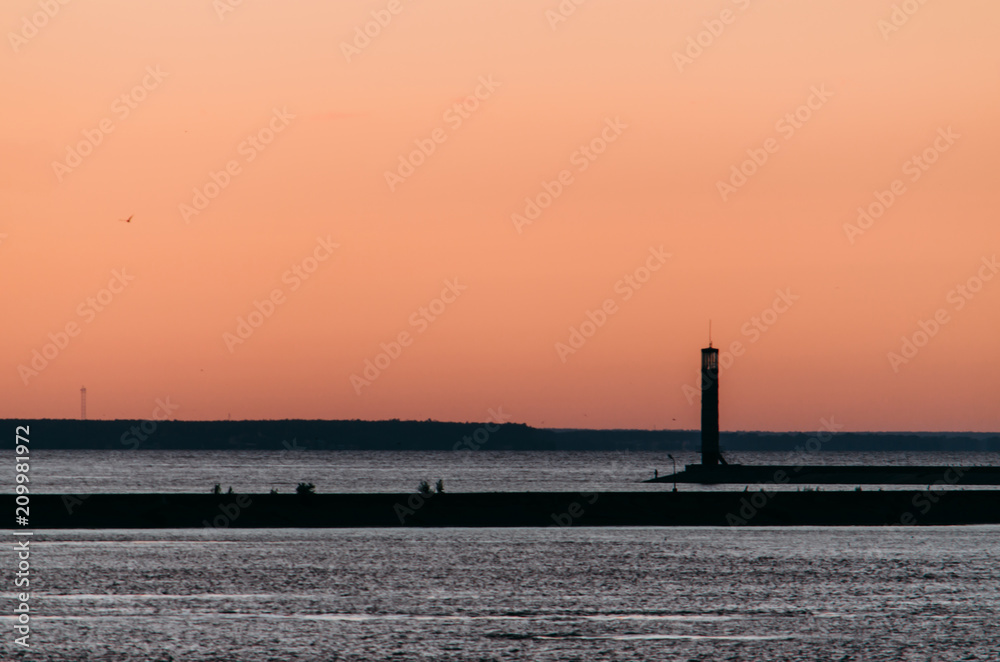 Landscape with silhouette of lighthouse in sunset light