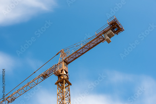 Wallpaper Mural Yellow construction crane against blue sky with white clouds. Torontodigital.ca