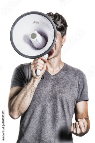 isolated portrait of a man shouting using a megaphone / young man holding a megaphone in protest attitude