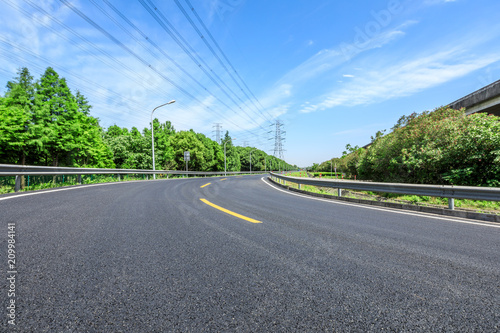 Curved asphalt highway and green forest on a sunny day © ABCDstock