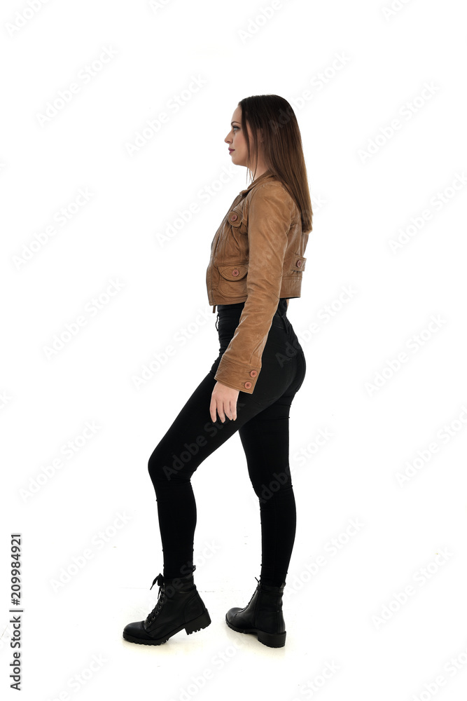 full length portrait of brunette girl wearing brown leather jacket. standing pose with back to the camera on white background. full length portrait of brunette girl wearing brown leather jacket. standing pose with back to the camera on white background.