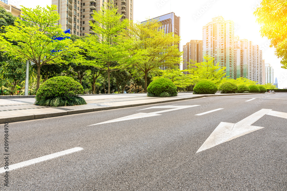 Asphalt road and modern commercial buildings and trees