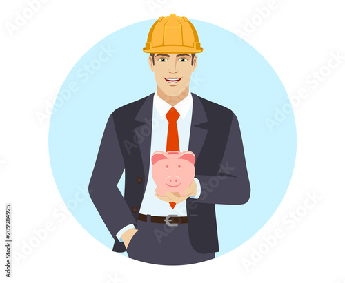 Businessman in construction helmet with hand in pocket with piggy bank