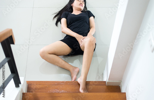 Hands female touching her legs injured,Asian woman falling down of staircase