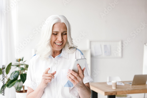 Mature cheerful woman indoors in office photo