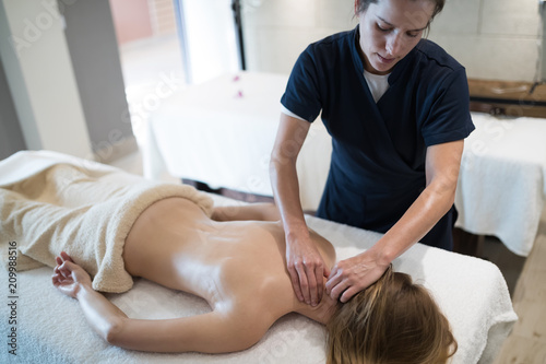 Therapist massaging patient at wellness spa