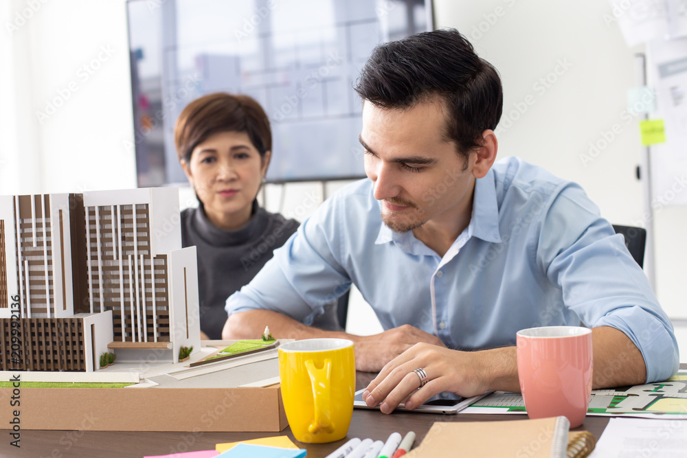 Close-up building model on table. Architect working with team with building project. Close-up building model on table. Architect working with team with building project.