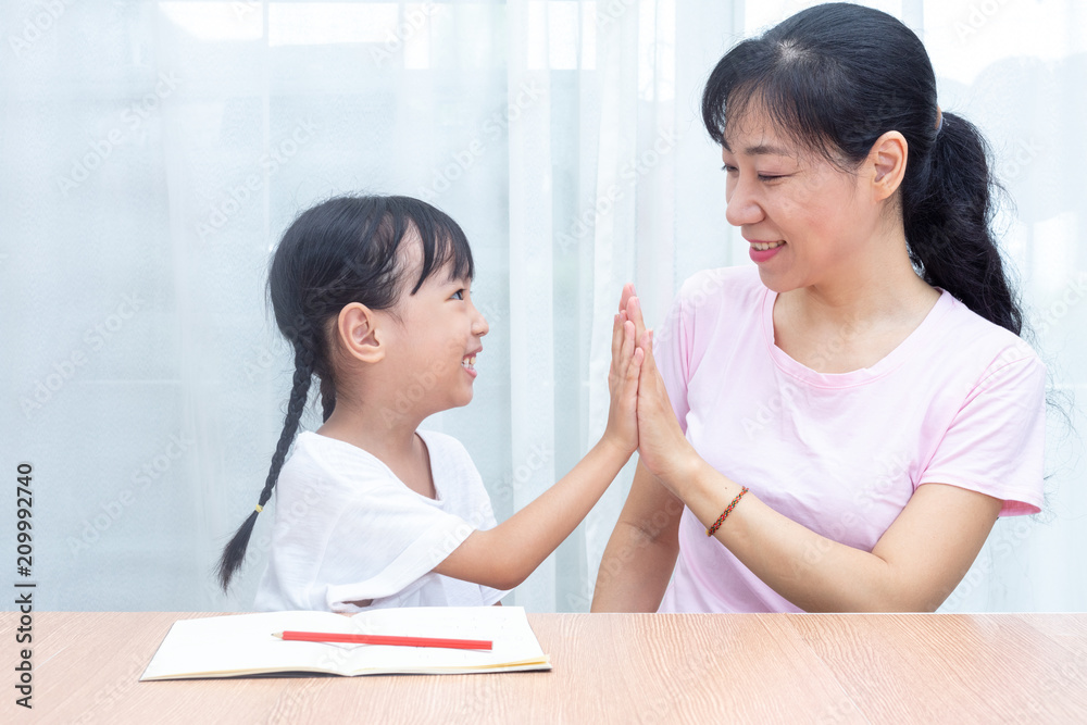 Asian Chinese mother and daughter high five each other Asian Chinese mother and daughter high five each other
