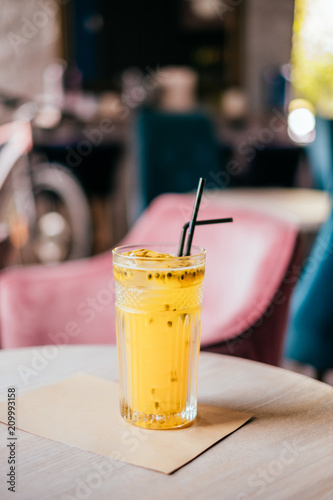Beautiful glass of yellow passionfruit lemonade on the wooden table. Flatlay style  spotted on the city cafe.