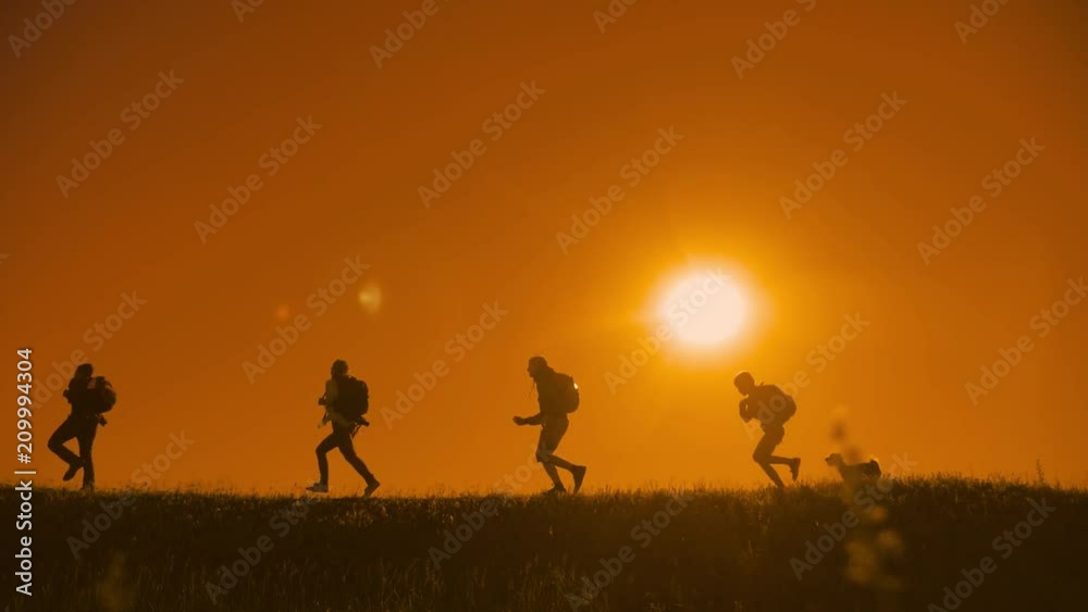 people hikers group happiness run and the dog silhouette of sunlight of tourists four people walking on top of a sunset silhouette mountain. slow motion running video tourists hiker people group go people hikers group happiness run and the dog silhouette of sunlight of tourists four people walking on top of a sunset silhouette mountain. slow motion running video tourists hiker people group go