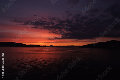 Sea in evening dusk in Bergen, Norway. Traveling with adventures to beautiful Norway. Seascape after sunset. Dramatic sky over sunset sea water. sunrise. Beauty of nature. Wanderlust and vacation