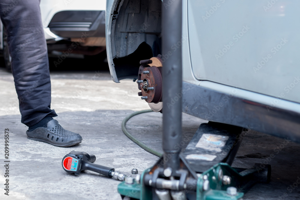 Mechanic is changing car wheel at tyre shop. Mechanic is changing car wheel at tyre shop.