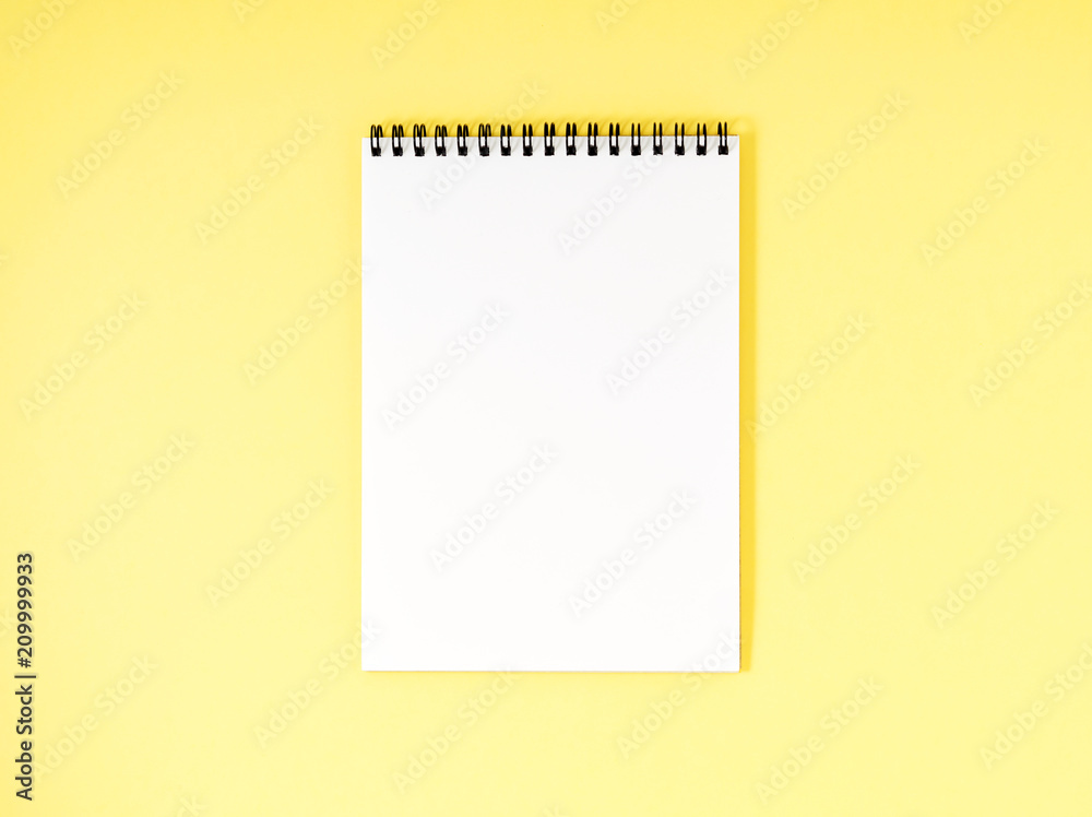 Blank notepad white page on yellow desk, color background. Top view, empty space for text. Blank notepad white page on yellow desk, color background. Top view, empty space for text.