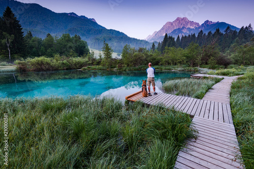 Active man with dog watching sunrise in Zelenci Park, Slovenia