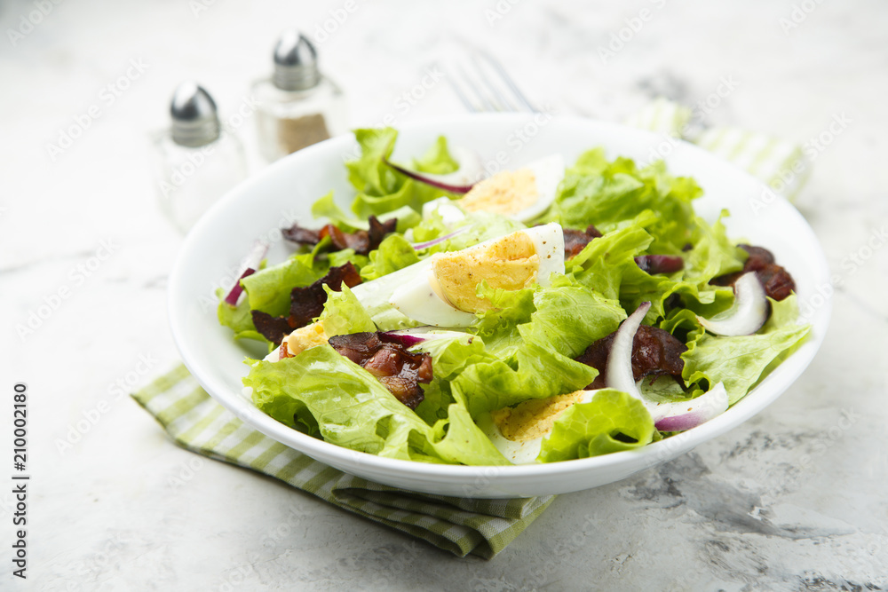 Lettuce salad with fried bacon, red onion and hard boiled egg Lettuce salad with fried bacon, red onion and hard boiled egg