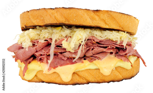 Pastrami Reuben style sandwich with sauerkraut and Swiss cheese isolated on a white background
