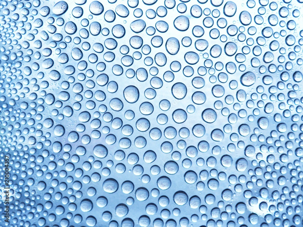 Water drops on the glass in a cool blue tones. in the rainy season. For design, textures and backgrounds. Water drops on the glass in a cool blue tones. in the rainy season. For design, textures and backgrounds.