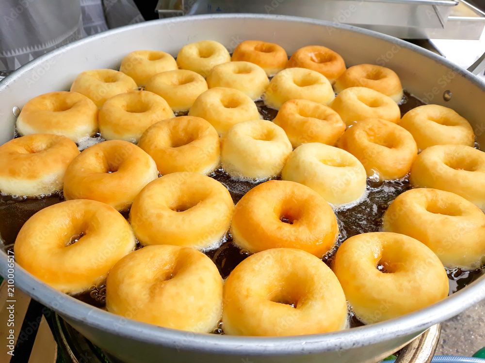 Donuts fried in hot oil in pan. Donuts fried in hot oil in pan.