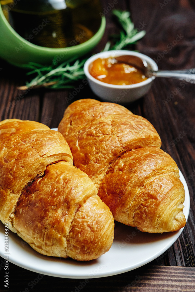 fresh croissants with jam on dark wooden table and tea with rosemary, fresh croissants with jam on dark wooden table and tea with rosemary,