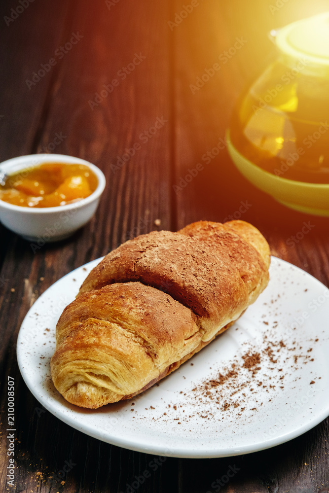 fresh croissants with jam on dark wooden table and tea with rosemary, sunshine, chocolate on food fresh croissants with jam on dark wooden table and tea with rosemary, sunshine, chocolate on food