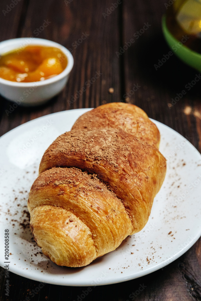 fresh croissants with jam on dark wooden table and tea with rosemary, chocolate on food fresh croissants with jam on dark wooden table and tea with rosemary, chocolate on food